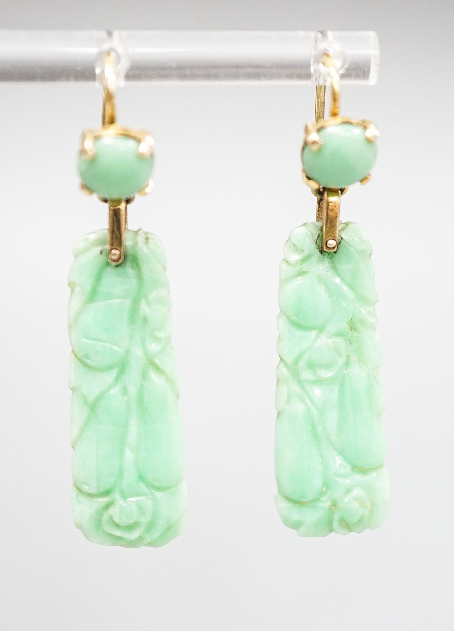 A pair of yellow metal mounted carved jade drop earrings, 43mm, gross 6.8 grams.